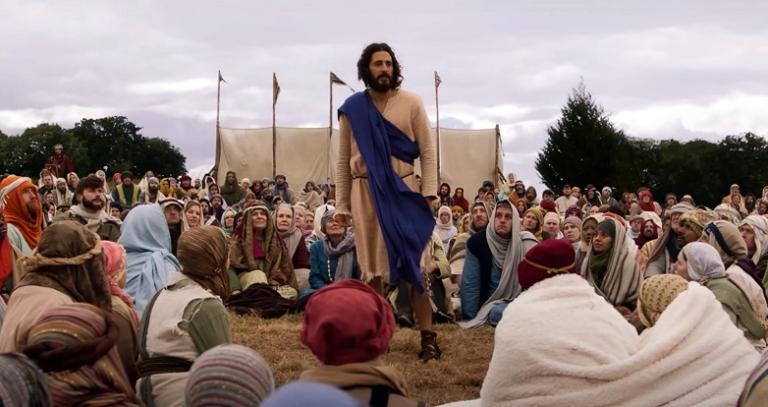 Jesus delivers a sermon to a crowd.