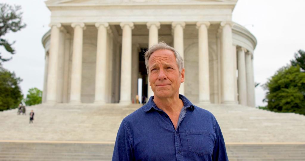 A man stands in front of a Washington, D.C., memorial.