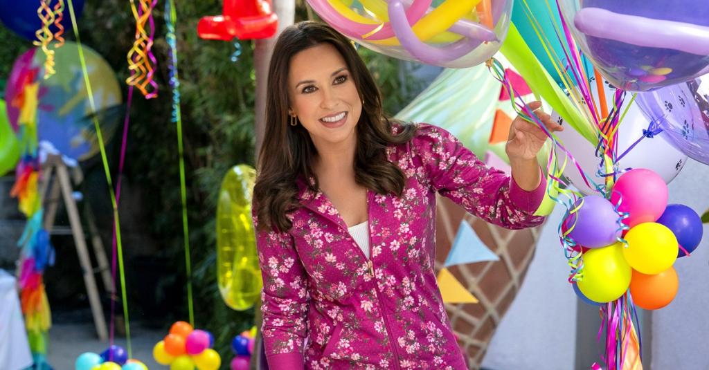 Lacey Chabert holds balloons in a party atmosphere.