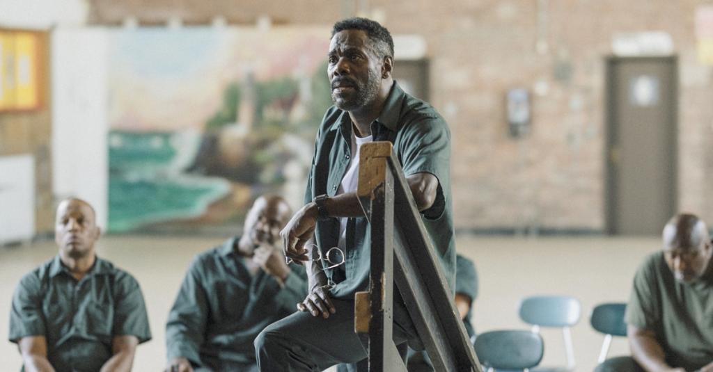 Colman Domingo, playing a prison inmate, stands on the steps of the prison theater stage.