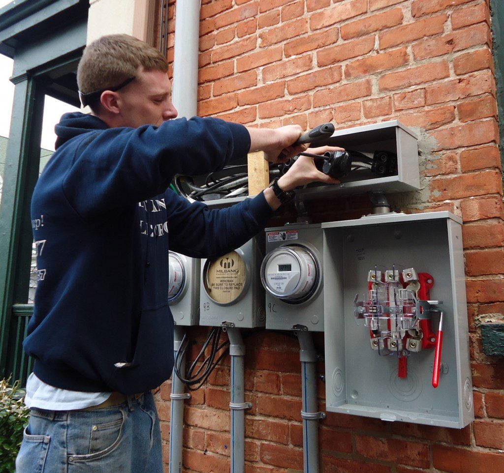 from https://commons.wikimedia.org/wiki/File%3AElectrician_installing_outdoor_connections_on_multifamily_house.JPG, By Tomwsulcer (Own work) [CC0], via Wikimedia Commons
