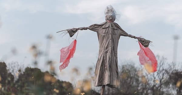 an eerie scarecrow mounted above a field