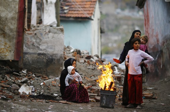 Syrian refugees warm themselves around fire in Turkey