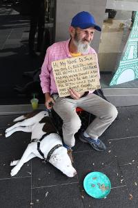 Photo of homeless man with cardboard sign