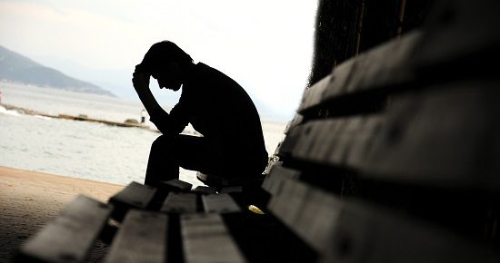 depressed young man sitting on the bench