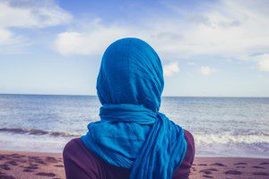 Rear view of woman with headscarf looking at the sea