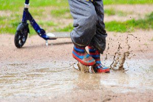 child playing in water puddle, kids outdoor