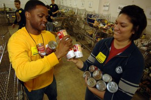 Air Traffic Controller 2nd Class Lamar Jones, left, and Air Traffic Controller 3rd Class Allison Hamm sort through canned goods at The Food Bank of Southeastern Virginia.