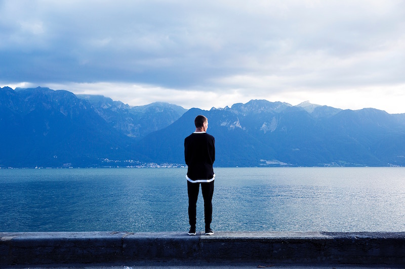 man staring at lake