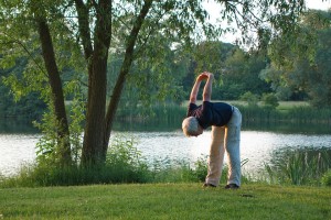 man doing yoga in park