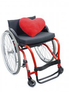 Red heart pillow on wheelchair isolated on white background