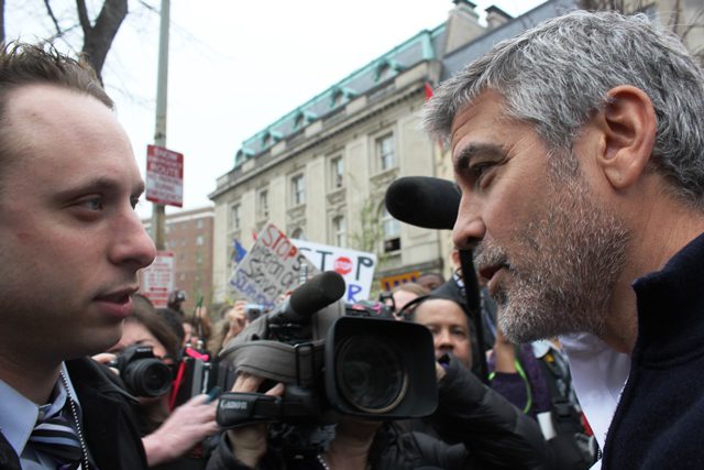 George Clooney speaks to a reporter as he arrested for trespassing at the Embassy of Sudan in Washington, DC, 2012.