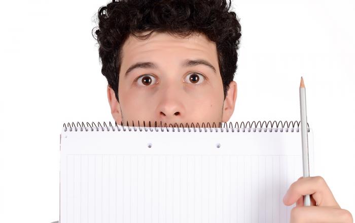 Close up of a young student holding notebook and pencil. Isolated white background.