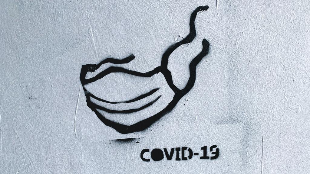 Graffiti image of a mask and the caption COVID-19