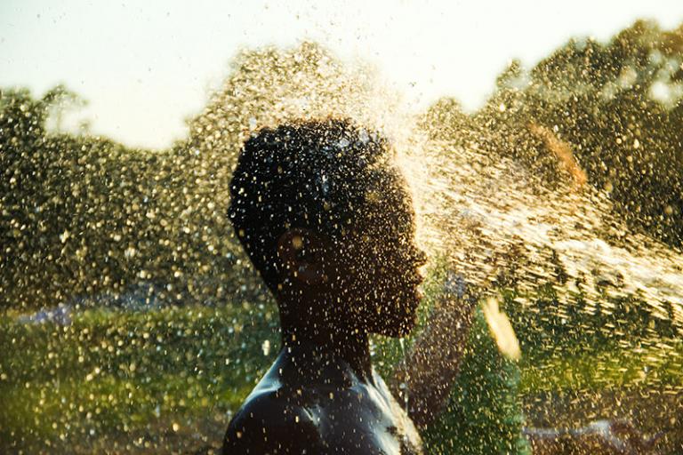 young man getting sprayed with water
