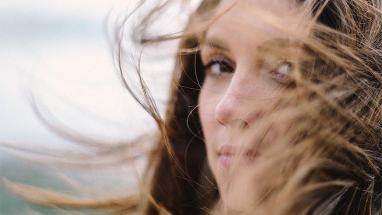 woman with hair blowing, eyes looking into the soul