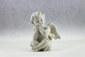 a ceramic cherub making a cutesy face