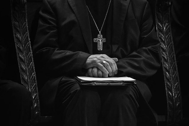 a bishop with clasped hands