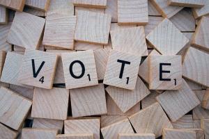 the word "vote" spread out in Scrabble tiles, for election day