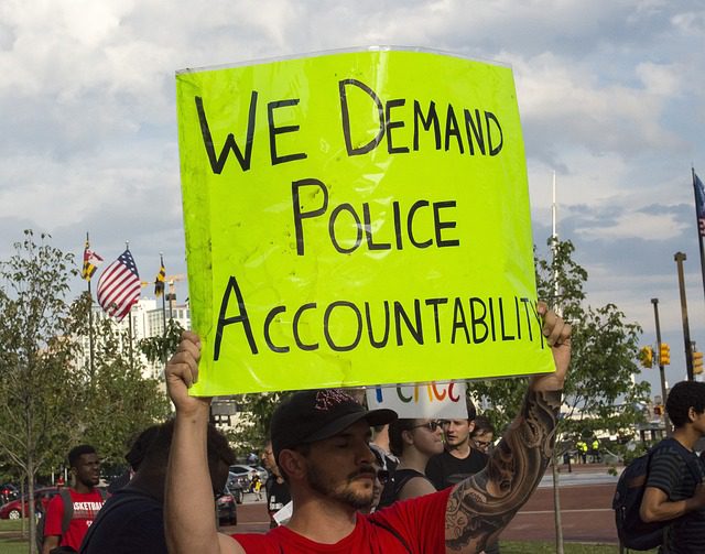 a man with a sign saying "we demand police accountability"