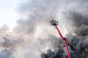fire fighters on a ladder truck, spraying water