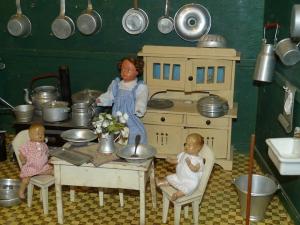dolls in a Victorian dollhouse kitchen