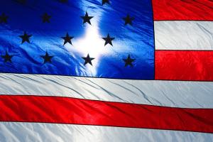 An American flag with a white cross on the blue field