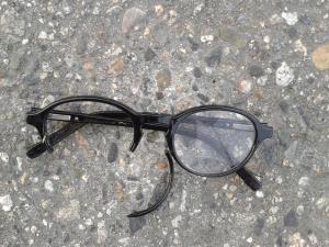 a pair of eyeglasses, broken on the ground