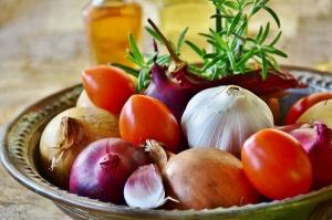 a bowl of onions, tomatoes and herbs