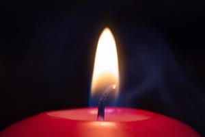 an Advent candle lit against a dark background