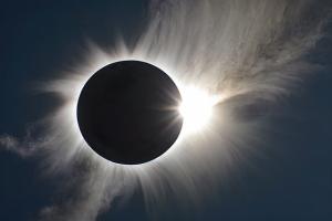 a photo of a solar eclipse, with a tiny sliver of the sun visible around the black circle of the moon
