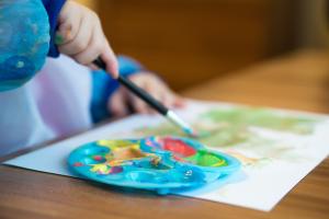 a child making a painting with messy tempera paint