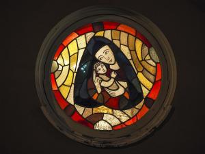 a stained glass window portraying the Virgin Mary holding baby Jesus