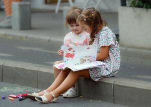 Children about Snow White and Rose Red's age, reading a book.