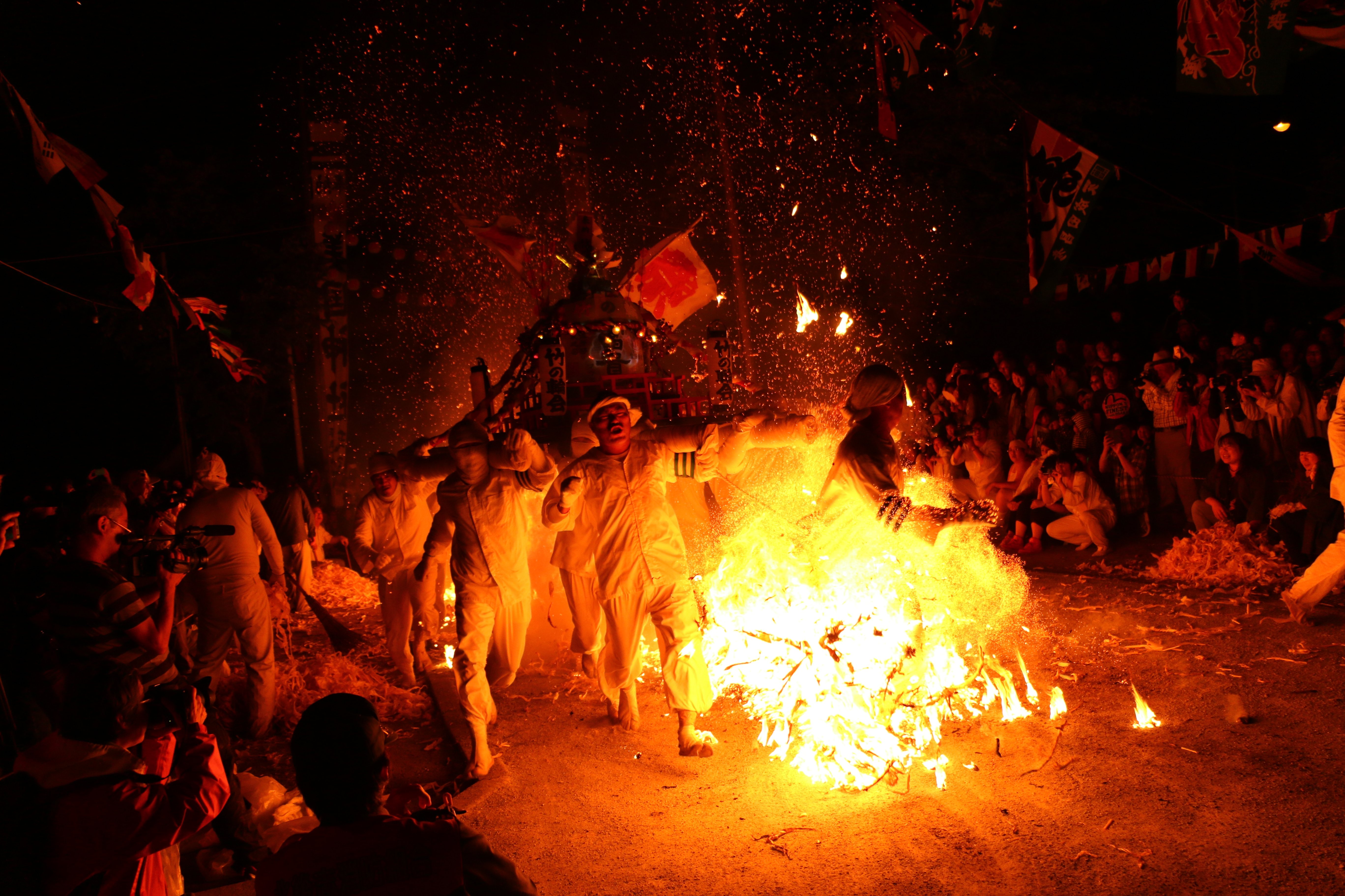 Group carrying a portable shrine through flames in Northern Japan