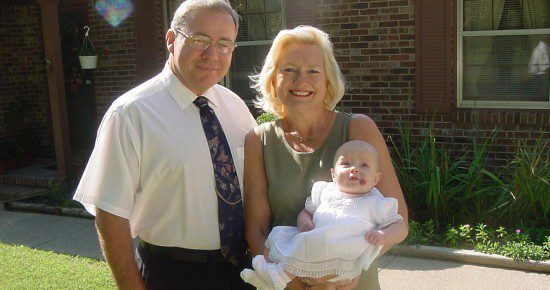 Mom and Skip with my baby daughter in front of her crocus beds, 2002.