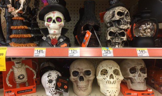 A shelf full of different Halloween decoration skulls