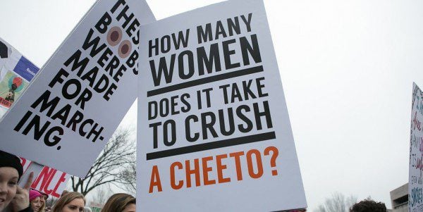 Sign reads: How many women does it take to crush a cheeto?