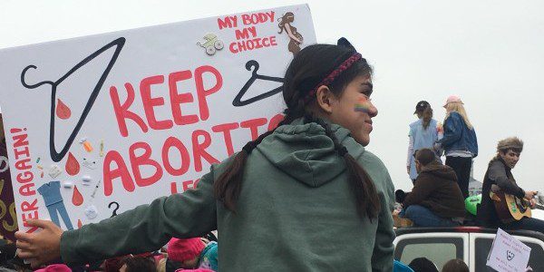 Keep Abortion Legal protest sign carried by a young girl on her father's shoulders