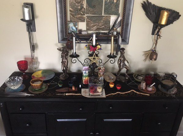 Heron's Personal Altar, dressed for Ostara, with current spell workings in progress, on a wooden side-board cabinet.