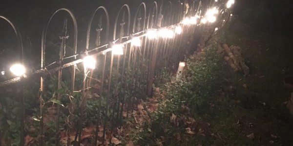 Cemetery Fence with Sanctuary Candles lit for all the Ancestors of the Land, buried there. ~Heron Michelle