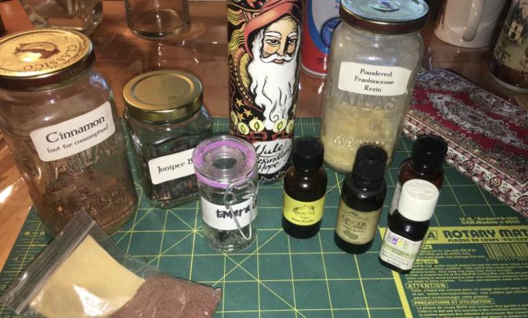 Ingredients for dressing the candle for Yule intention of "Rekindling Hope." - Witch on Fire