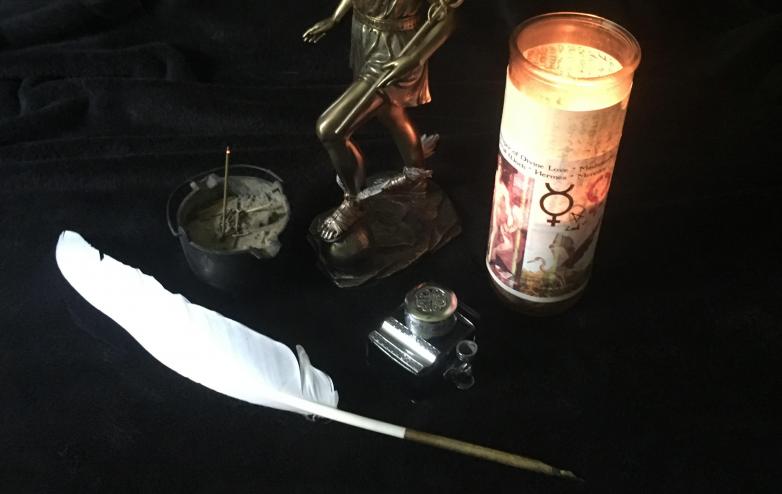 Example of Dedication Candle to Work with Hermes, with quill calligraphy pen, and ink-well of Dragon's Blood Ink, incense, etc. Photo by Heron Michelle