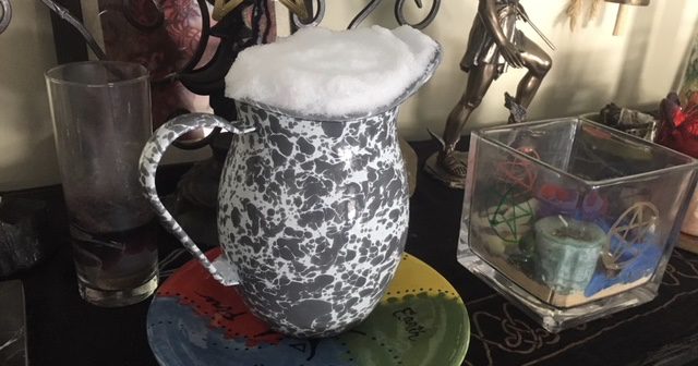 Collected Snow melting on Heron's altar patten, with candles and incense brning that align with water magick - Photo by Heron Michelle