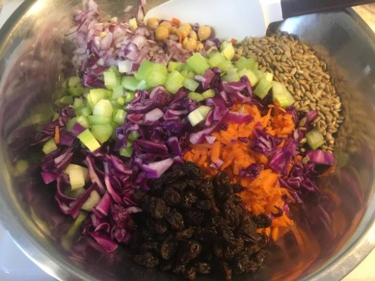 Bowl of veggies, seeds, chickpeas and raisons for mixing