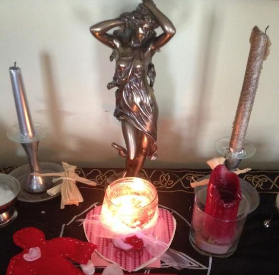 Aphrodite statue on altar with lit love spell candles