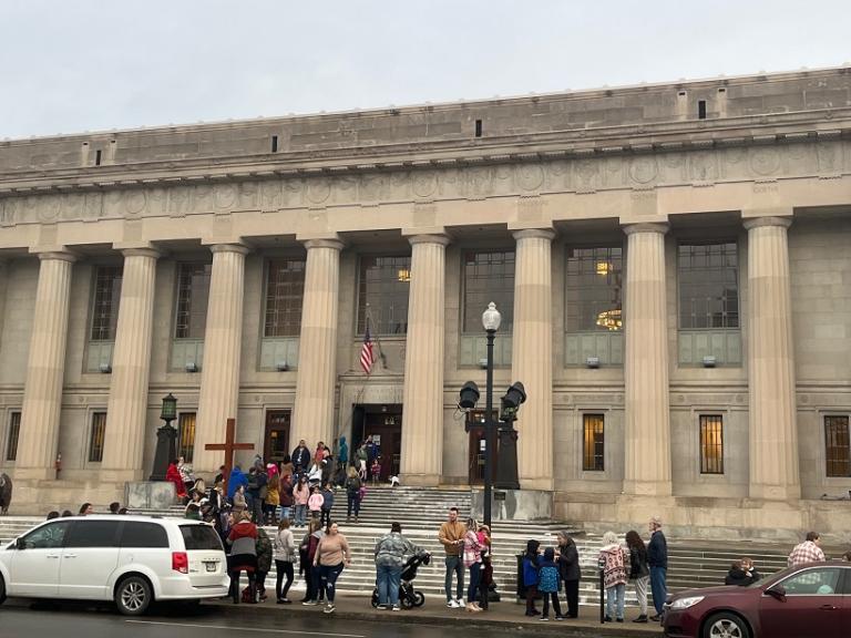 Crowd including man with cross outside Central Library in downtown Indianapolis on the morning of the Kirk Cameron event