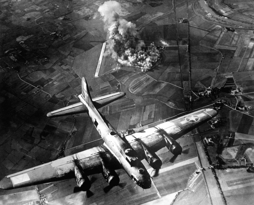 CLASSIC precision bombing featured this attack by 100 B-17s on a Focke-Wulf plant at Marienburg on Oct. 9, 1943. Results (above): two assembly buildings (1) gutted; another (2) damaged; hangars (3) gutted; stores and buildings (4) and boiler house (5) destroyed; other buildings (6) damaged. Cost to AAF: 2 B-17s. Pictures at left show target before (top) and during attack (bottom [5 B-17s]) Exact Date Shot Unknown NARA FILE #: 208-YE-7 WAR & CONFLICT BOOK #: 1087 (8th_AF_Bombing_Marienburg.JPEG) - PD-US (Army file)
