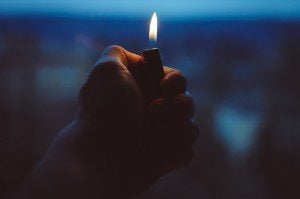 Man holding a lighter in the darkness