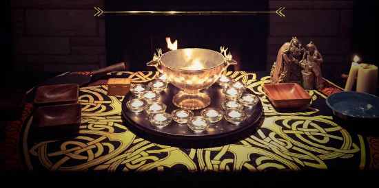 An altar with a silver bowl surrounded by lit candles.